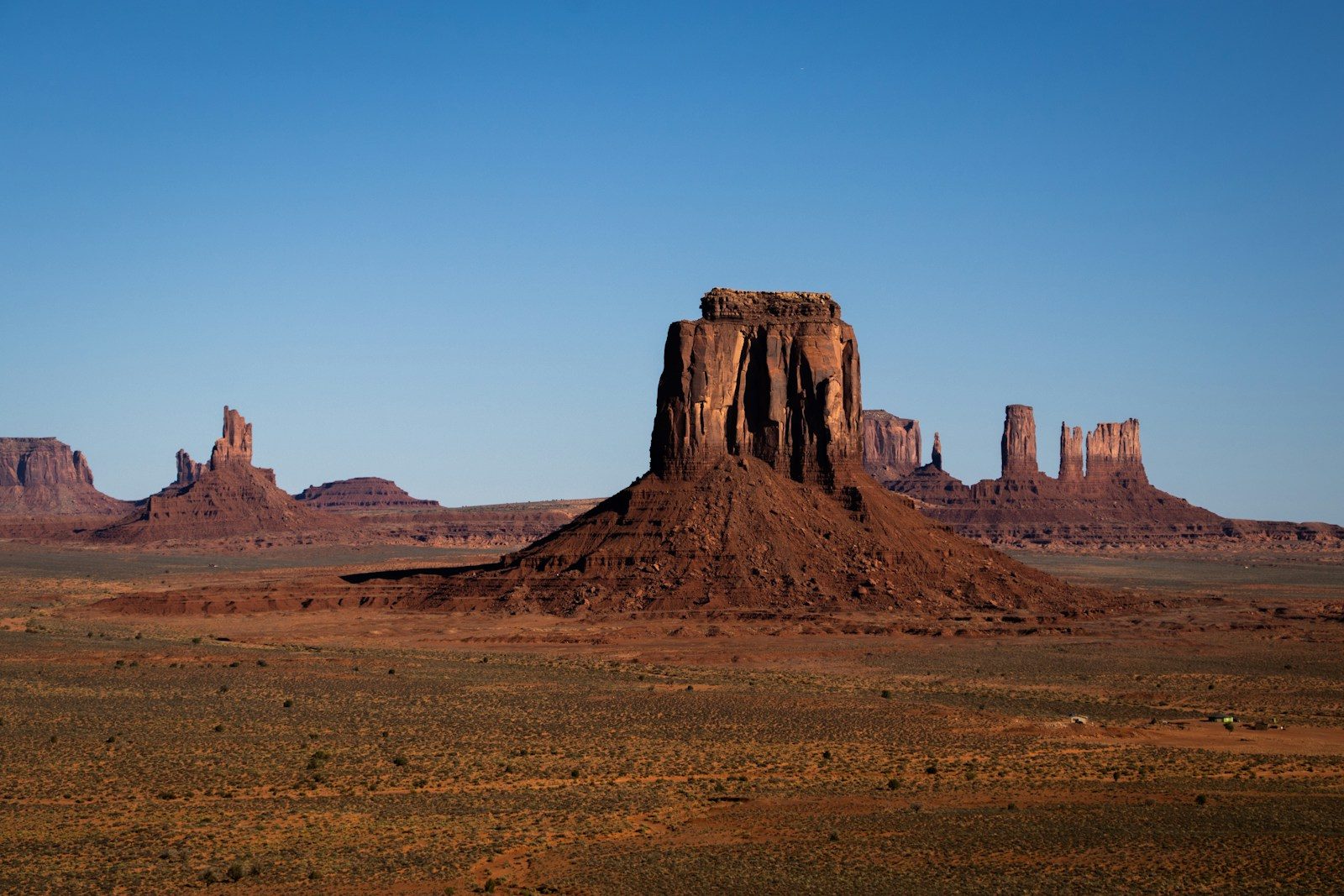 Monument valley sandstone buttes under a clear blue sky